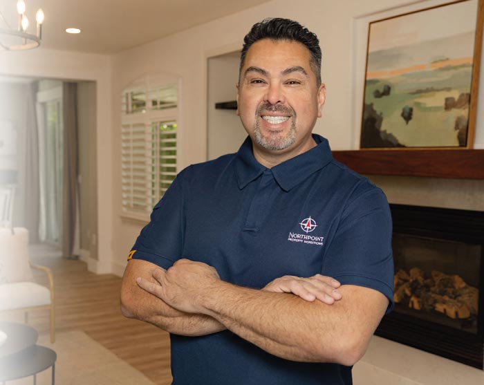 Oscar Solorio Fregoso, owner of Northpoint Property Inspections, standing in a professionally staged living room, representing decades of expertise as a licensed general contractor and ASHI Certified Home Inspector.